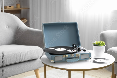 Record player with vinyl disk on table in living room © Pixel-Shot