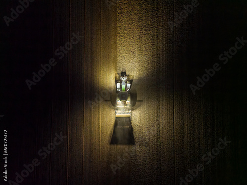 Aerial view of a tractor tilling a field in the early morning hours before sunrise