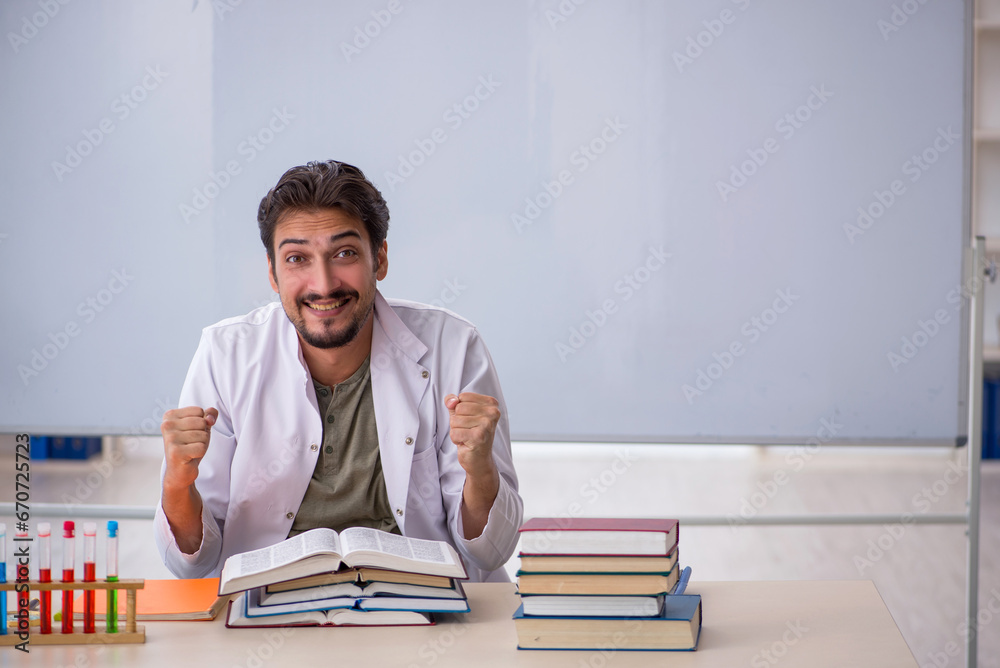 Young male chemist teacher in front of whiteboard Young male chemist teacher in front of whiteboard