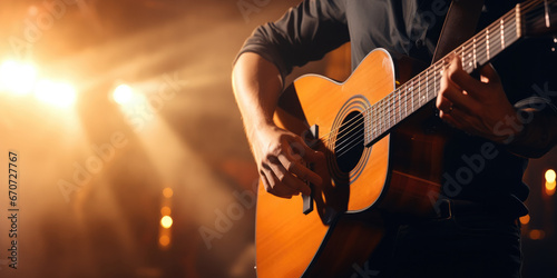 Close-up of acoustic guitar being played in concert setting