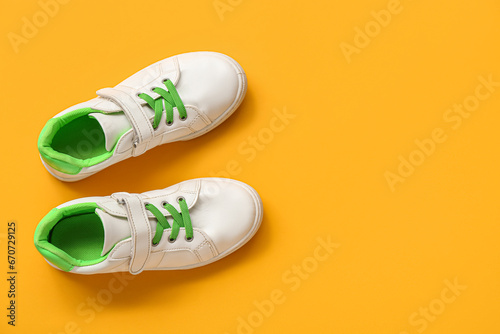Pair of stylish child's sneakers on color background