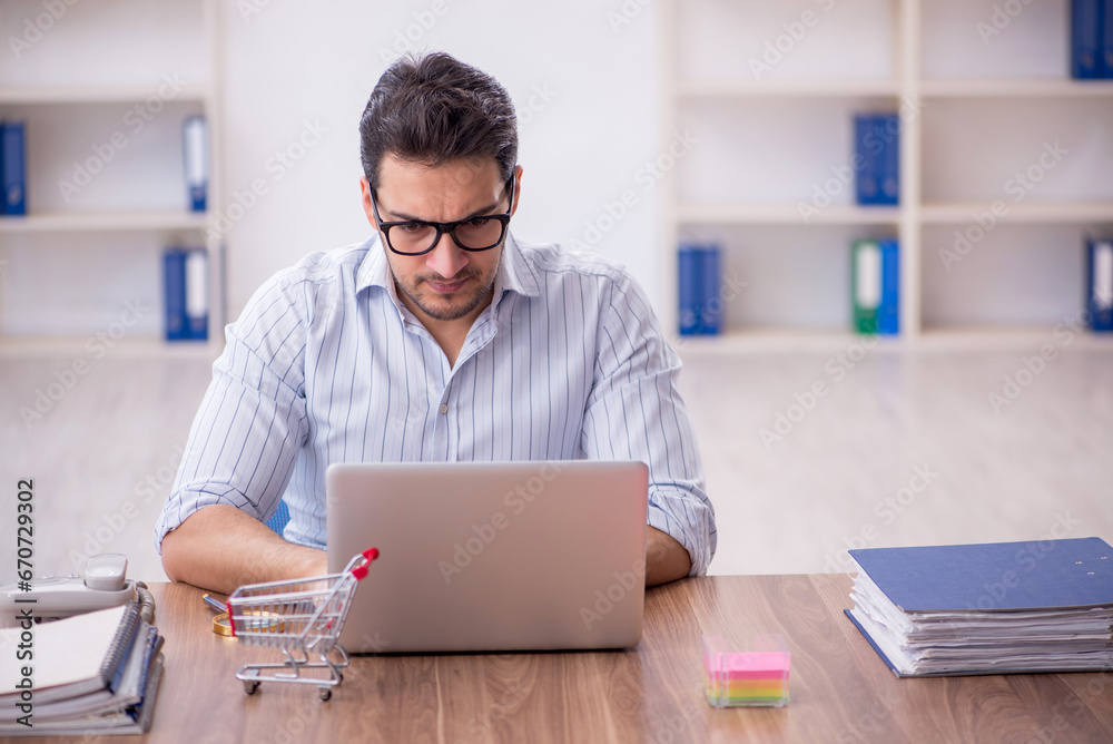 Young male employee in e-commerce concept Young male employee in e-commerce concept