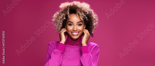 Smiling black young woman with dyed blonde hair looking at the camera on a magenta background