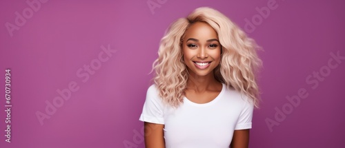 Smiling black young woman with dyed blonde hair looking at the camera on a magenta background photo