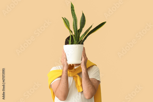 Young man with plant on bei...