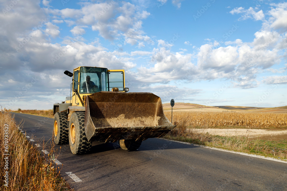 Obraz premium Bulldozer driving on a country road