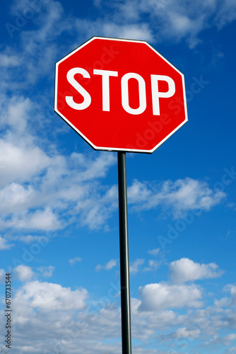 Stop Sign Against Blue Sky and Clouds