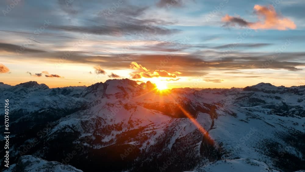 Tramonto sulle cime innevate delle alpi, riflessi del sole nelle nuvole fino alla sua scomparsa Tramonto sulle cime innevate delle alpi, riflessi del sole nelle nuvole fino alla sua scomparsa
