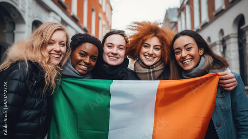 cheerful friends holding the flag of Ireland on the street of Dublin, young smiling Irish women, symbol of the country, St. Patrick's Day, international, joyful girls in the city, national, green