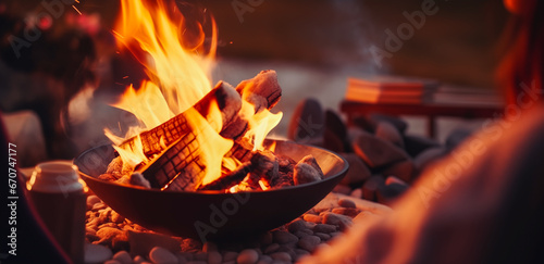 Flames in a fire in a fire pit. Cast iron fire pit campfire place at forest beach camping with bright burning flame at evening time