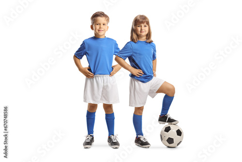 GIrl and boy in football jerseys posing with a ball