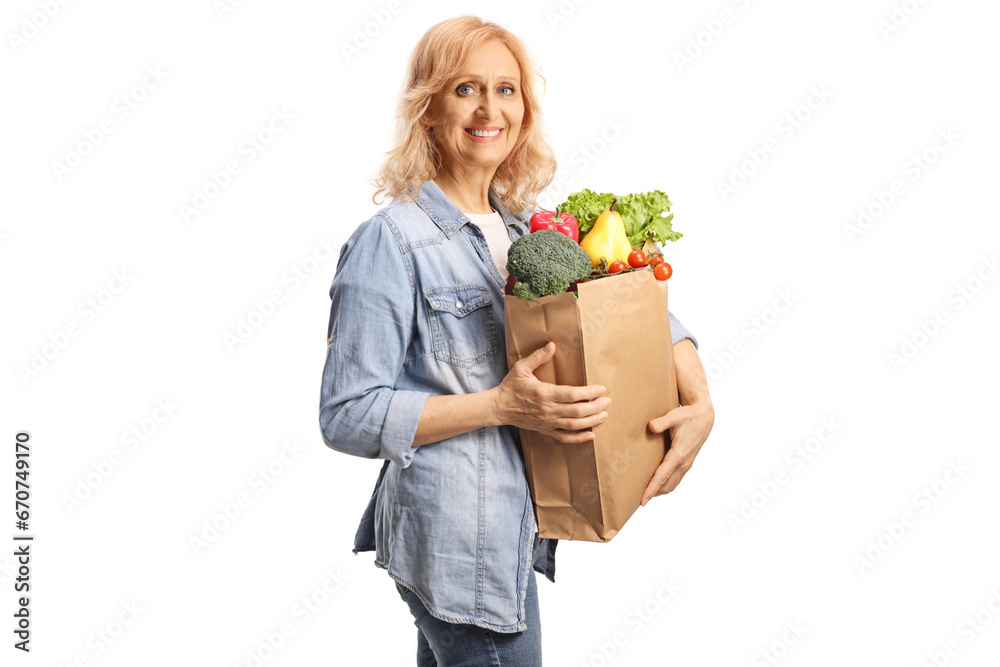 Mature woman with a grocery bag smiling at camera Mature woman with a grocery bag smiling at camera
