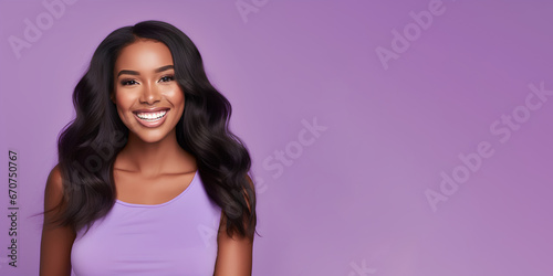 Smimilg young woman with dark skin and long groomed hair isolated on flat violet pastel background with copy space. Model for banner of cosmetic products, beauty salon and dentistry
