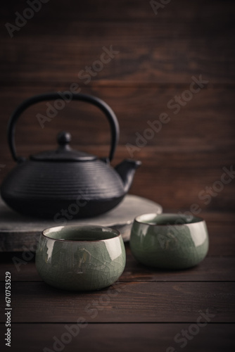 Cast iron black teapot and two bowls of tea