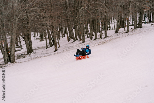 Man sledding down a hill lying on his back