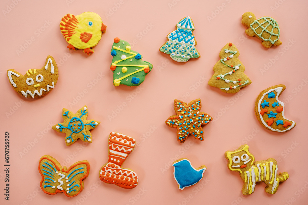 Colorful Christmas cookies lie on a pink table
