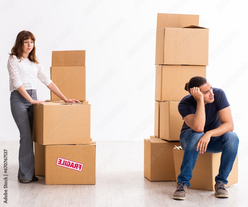Young pair and many boxes in divorce settlement concept Young pair and many boxes in divorce settlement concept