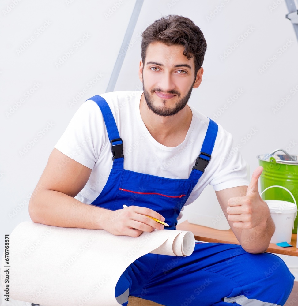 Repairman doing renovation repair in the house with paper wallpa Repairman doing renovation repair in the house with paper wallpa