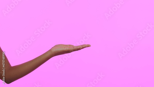 Hands, palm and advertising space in studio for mockup, launch presentation and information about us on pink background. Closeup, model and show choice of promotion, sales announcement and offer deal © Anela R/peopleimages.com