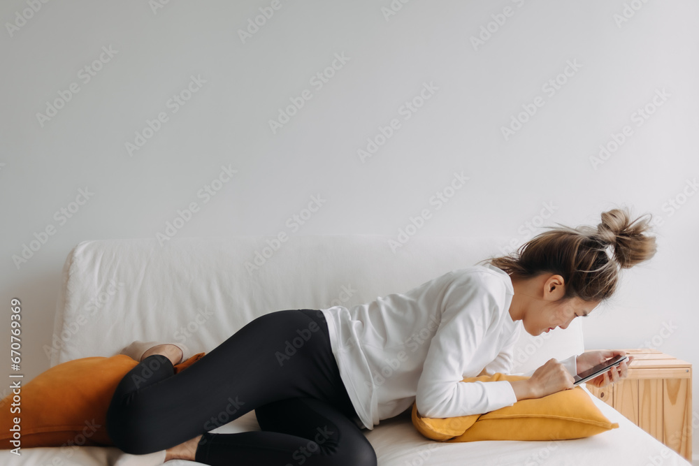 Asian woman using smartphone relaxed on sofa in cold day. Asian woman using smartphone relaxed on sofa in cold day.