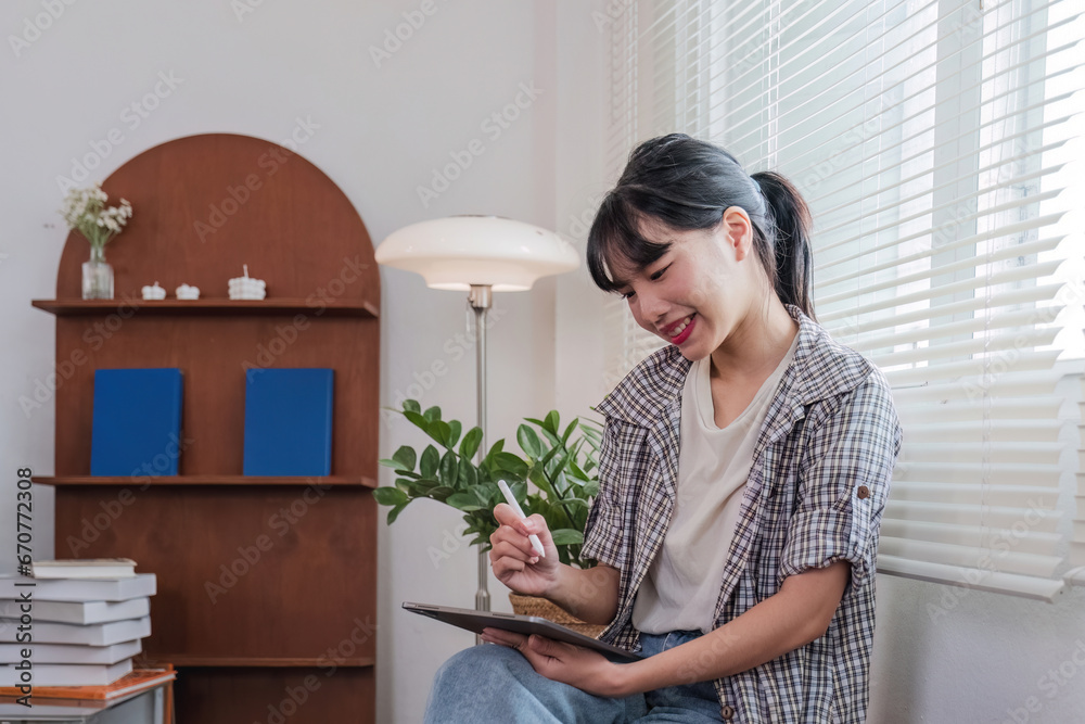 Asian female student studying online through zoom meeting program. Happy Asian girl studying English online with tablet. Asian female student studying online through zoom meeting program. Happy Asian girl studying English online with tablet.