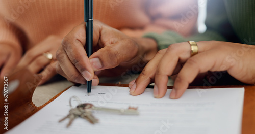 Closeup, hands and signature on mortgage paperwork for finance, home contract or a loan. Investment, legal and a couple writing on a document for keys of a house, ownership and agreement for a deal