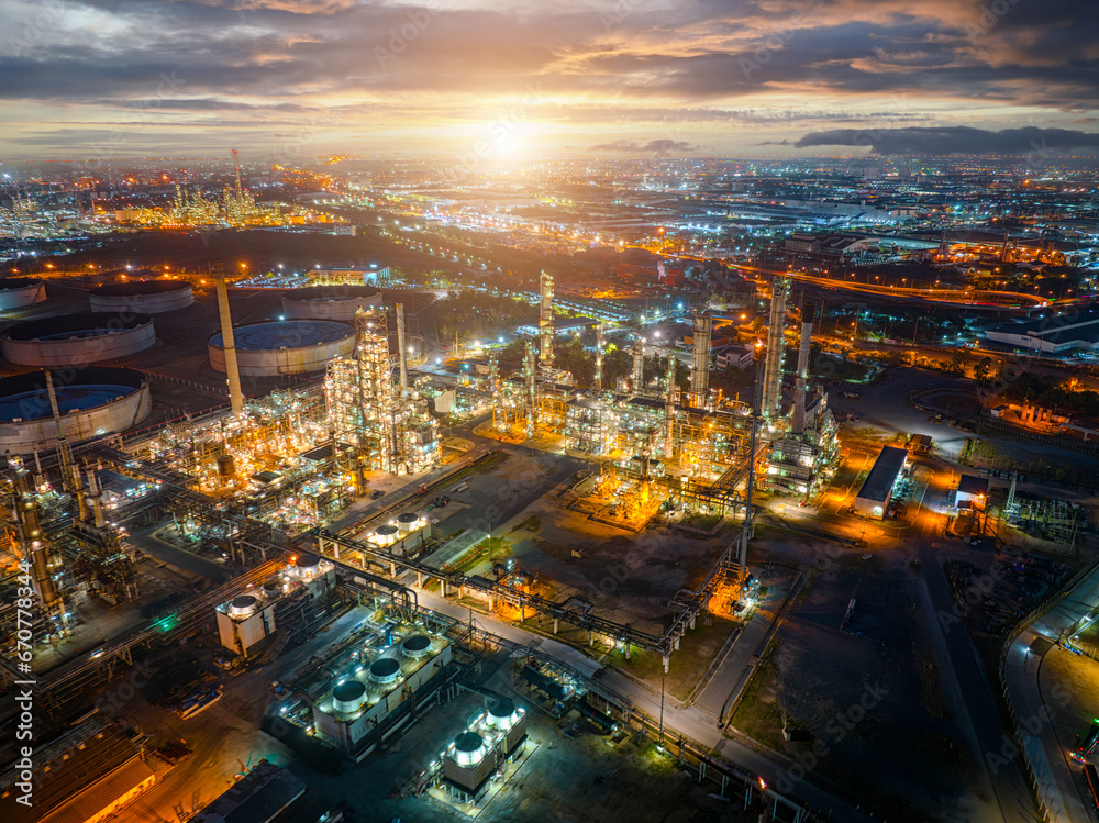 Fototapeta premium Aerial view of the petrochemical, oil and gas industry. Industrial field, oil refinery storage tanks and steel pipelines at night, ecology and health. 