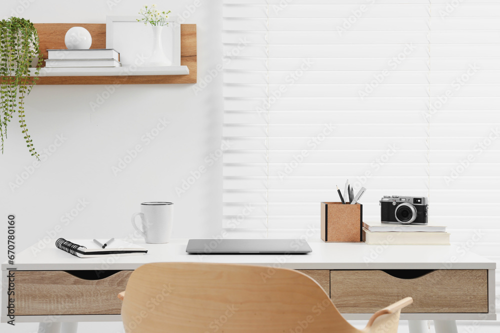 Home office. Stylish workplace with laptop and stationery on white desk indoors. Space for text