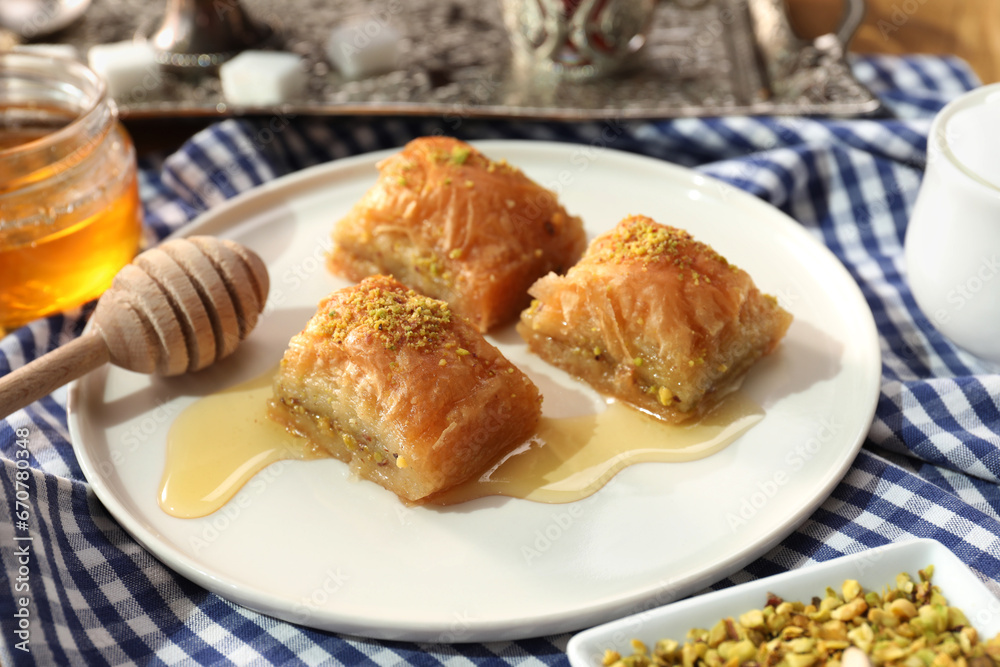 Delicious sweet baklava with pistachios and honey on table, closeup