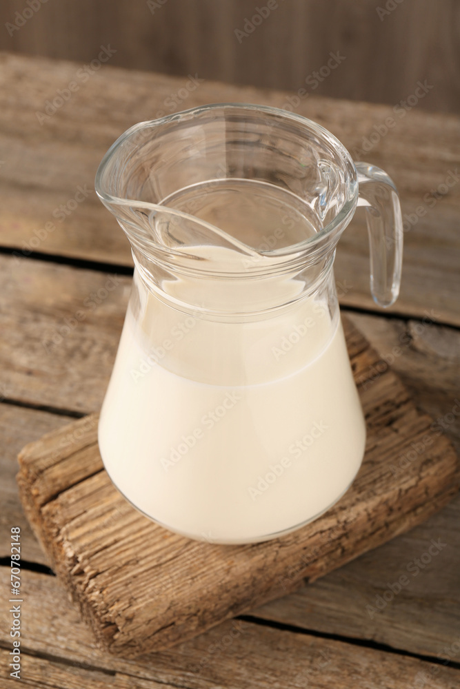 Jug of fresh milk on wooden table Jug of fresh milk on wooden table