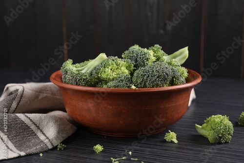 Fototapeta Naklejka Na Ścianę i Meble -  Bowl with fresh raw broccoli on black wooden table