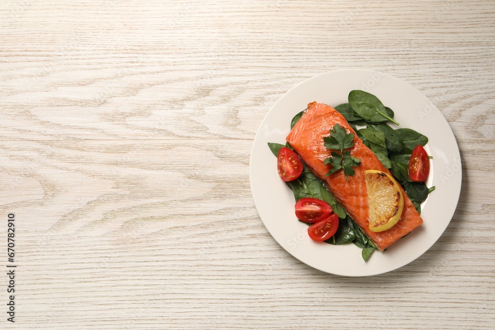 Tasty grilled salmon with tomatoes, lemon and basil on white wooden table, top view. Space for text Tasty grilled salmon with tomatoes, lemon and basil on white wooden table, top view. Space for text