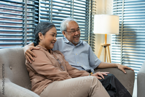 Asian senior elderly couple watching television in living room at home.