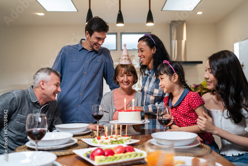 Multi-ethnic big family having birthday party for senior grandmother. 