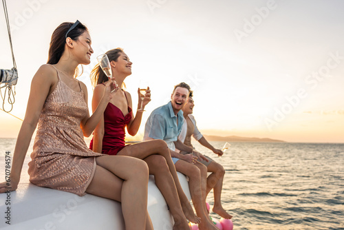 Group of diverse friends drink champagne while having a party in yacht. © Kawee