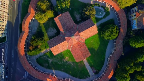 Aerial view of the Rotunda della Besana. Blue sky. Historical buildings in the city. A cruciform church surrounded by a wall. Cinematic filming using FPV drone. Tiled roofs. architecture Milan Italy photo