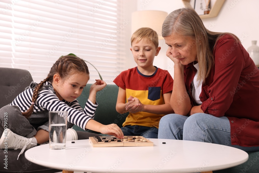 Family playing checkers at coffee table in room Family playing checkers at coffee table in room