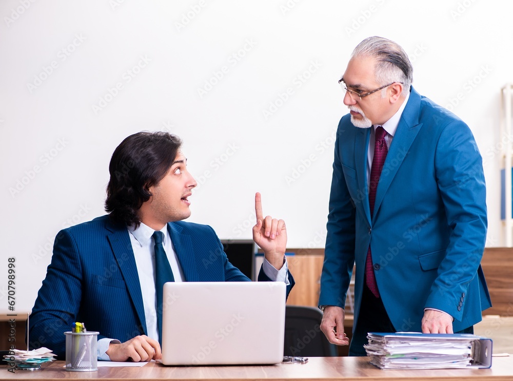 Young and old employees working together in the office Young and old employees working together in the office