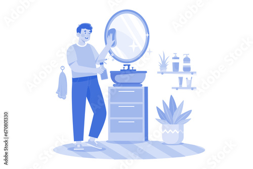 Man Cleaning Mirror In The Bathroom