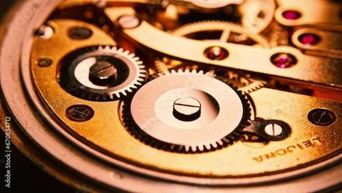 Mechanism and gears of an old pocket watch. Macro close up shot. Stationary chrome gear on the foreground, lights and reflections move on the metal surfaces as the camera pans.
