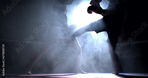 Two fighters facing each other inside boxing ring with dramatically lit with spotlight captured in slow-motion at 800 fps. Opponent face to face photo