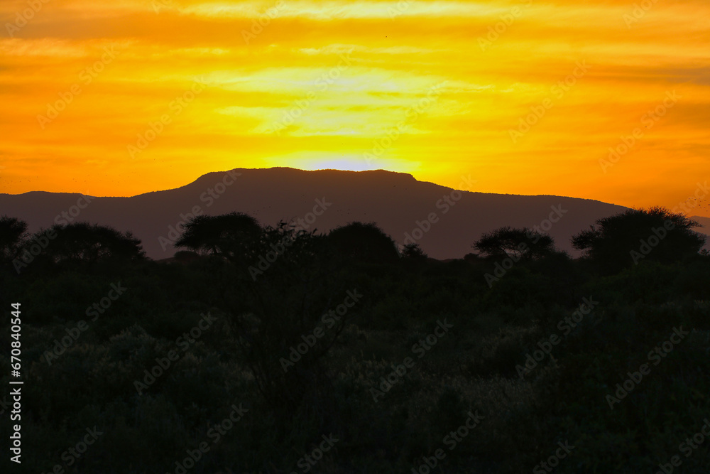 The dusty savanna of Tsavo and the red clay produces fiery sunsets over Tsavo East National Park, Kenya, Africa