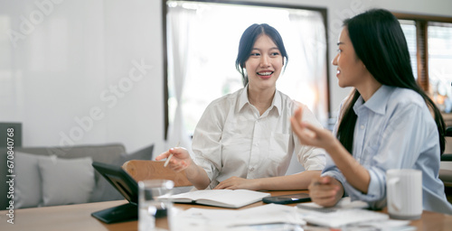 Businesswomen Collaborating In Creative Meeting, sitting at table In home Office