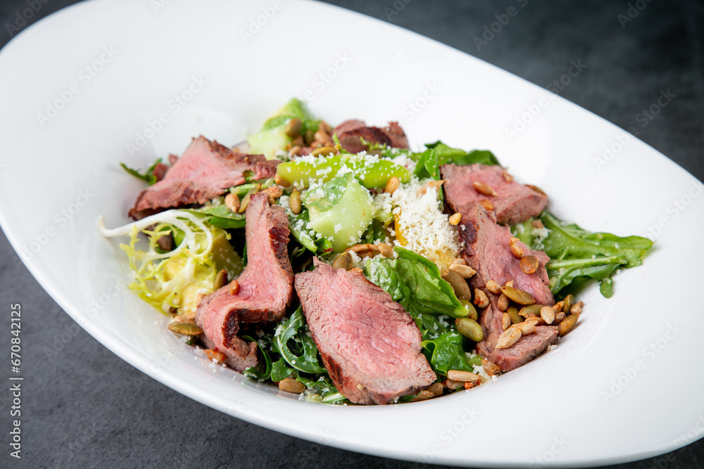 salad with pieces of beef, pistachios, lettuce and cheese side view salad with pieces of beef, pistachios, lettuce and cheese side view