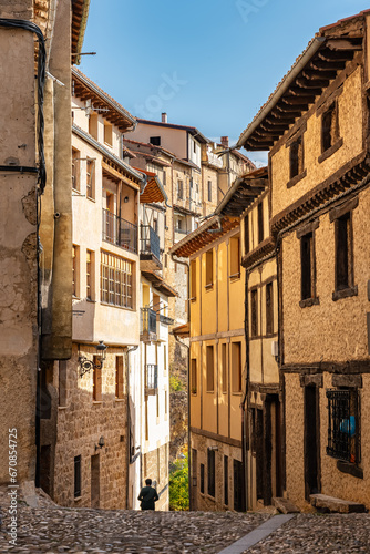 Alley with old houses and cobblestones on the ground in the picturesque village of Frias, Burgos, Spain. © josemiguelsangar