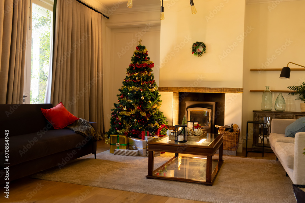 Decorated christmas tree by fireplace in homely living room, copy space