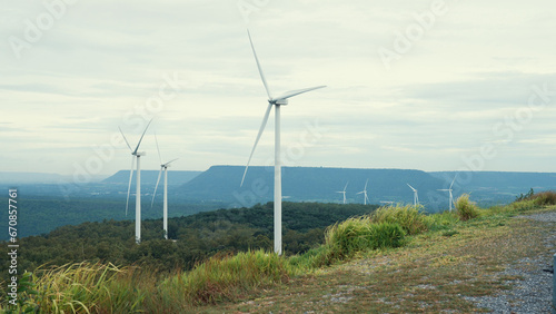 Progressive way of utilizing wind as renewable source of energy to power the modern way of life by wind turbine farm on green field or hill. Windmill generator generate electric with no CO2 emission.