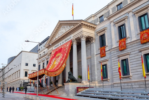 The Congress of Deputies is decked out to receive the Kings of Spain and the Princess of Asturias on their birthday. The lion of the courts next to the flag of Spain. photo