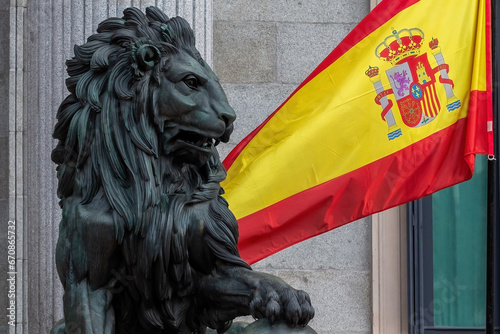 The Congress of Deputies is decked out to receive the Kings of Spain and the Princess of Asturias on their birthday. The lion of the courts next to the flag of Spain. photo