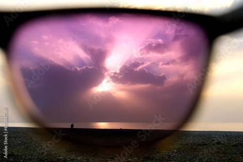 Obraz na plátně View on seascape sea and sunset sky through polarizing purple sunglasses